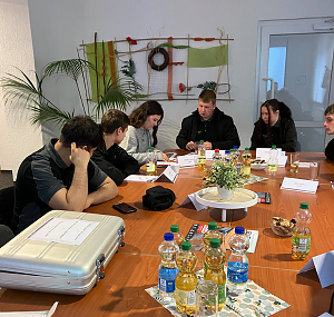 Azubis arbeiten gemeinsam am Tisch an der Lösung der Rätsel