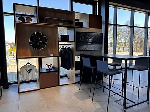 Regalsystem mit Merchandise von CUPRA mit TV im Ausstellungsraum