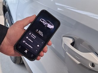 Smartphone mit Connect App vor einem Auto(Ratio Mobil)