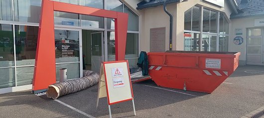 Baustellenschild und Container vor dem Eingang des Autohauses (Ratio Mobil)